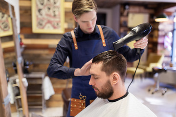 Image showing barber with fan drying male hair at barbershop