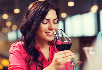 Image showing smiling woman drinking red wine at restaurant