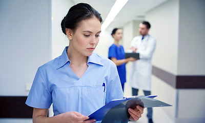 Image showing female doctor or nurse with clipboard at hospital