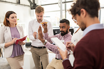 Image showing happy business team discussing something at office