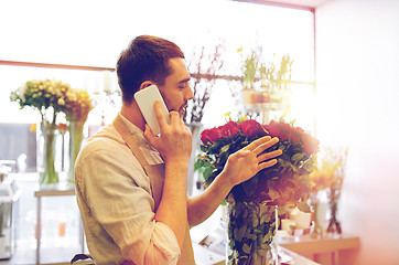 Image showing man with smartphone and red roses at flower shop