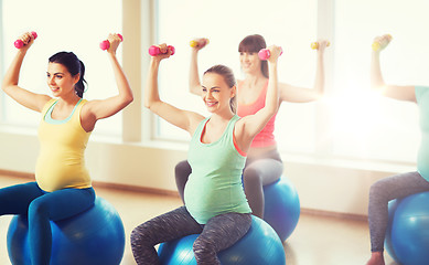 Image showing happy pregnant women exercising on fitball in gym