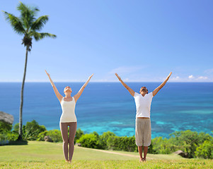 Image showing happy couple making yoga exercises on beach