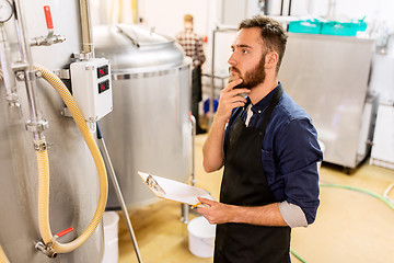 Image showing man with clipboard at craft brewery or beer plant