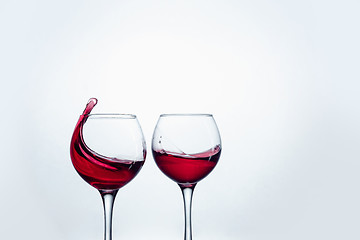 Image showing Two wine glasses in toasting gesture with big splashing.