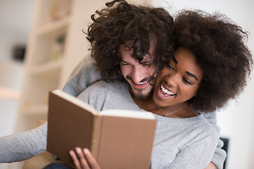 Image showing multiethnic couple hugging in front of fireplace