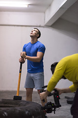 Image showing man workout with hammer and tractor tire