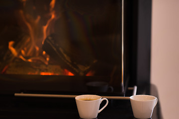 Image showing two mugs in front of fireplace