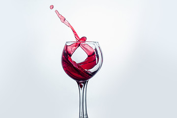 Image showing Two wine glasses in toasting gesture with big splashing.