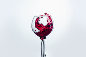 Image showing Two wine glasses in toasting gesture with big splashing.