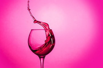 Image showing The one wine glass against red