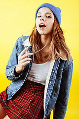 Image showing lifestyle people concept: pretty young school teenage girl having fun happy smiling on yellow background close up