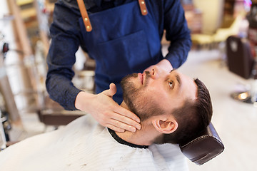 Image showing barber applying aftershave lotion to male neck