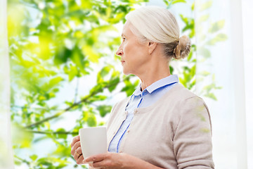 Image showing lonely senior woman with cup of tea or coffee