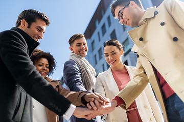 Image showing group of happy people holding hands in city