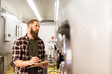 Image showing man with clipboard at craft brewery or beer plant