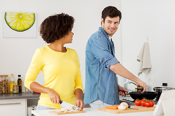 Image showing happy couple cooking food at home kitchen