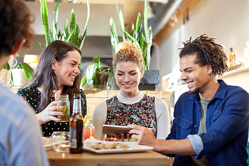 Image showing friends with tablet pc, drinks and food at bar