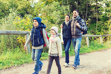 Image showing happy family with backpacks hiking in woods