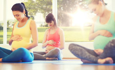 Image showing happy pregnant women exercising yoga in gym