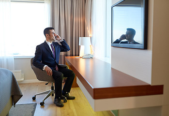 Image showing businessman calling on smartphone at hotel room