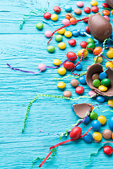 Image showing Multicolored dragees, chocolate eggs, ribbons