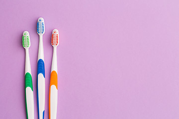 Image showing Photo of three colored toothbrushes