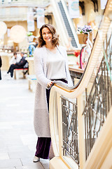 Image showing Smiling woman in a knitted bright summer coat