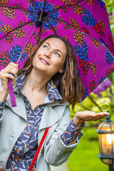 Image showing Smiling woman with umbrella in the rain