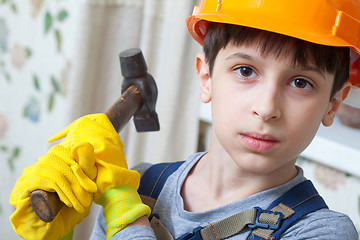 Image showing boy in a protective helmet and with a hammer 