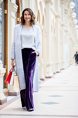 Image showing miling beautiful middle aged woman in knitted bright summer coat