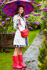 Image showing happy middle-aged woman in rubber boots with umbrella