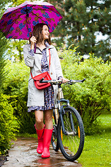 Image showing beautiful middle aged woman with umbrella and bicycle