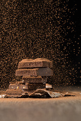 Image showing Broken chocolate with sprinkled cocoa