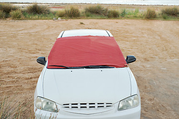 Image showing Windshield of white car covered by piece of fabric