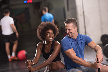 Image showing multiethnic couple after workout with hammer