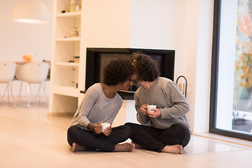 Image showing multiethnic couple  in front of fireplace