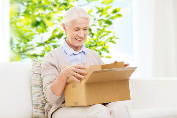 Image showing happy senior woman with parcel box at home
