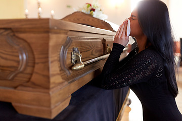 Image showing woman with coffin crying at funeral in church