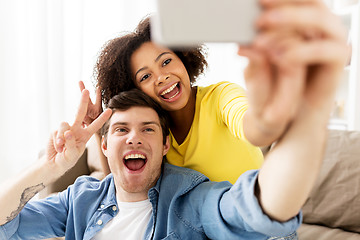 Image showing happy couple with smartphone taking selfie at home