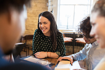 Image showing happy friends looking to menu at restaurant