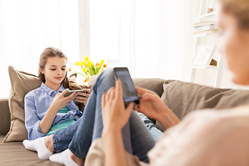 Image showing happy family with smartphones at home