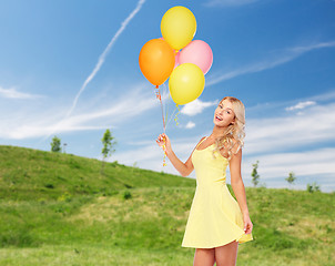 Image showing happy woman with helium air balloons in summer