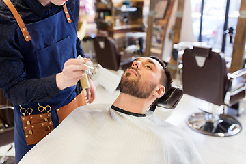 Image showing barber cleaning male face with brush at barbershop