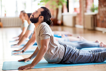 Image showing group of people doing yoga cobra pose at studio