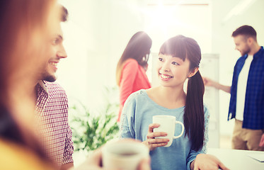 Image showing happy creative team drinking coffee at office