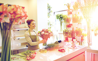 Image showing smiling florist woman making bunch at flower shop