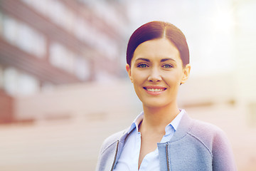 Image showing young smiling businesswoman over office building