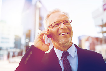 Image showing smiling old businessman calling on smartphone