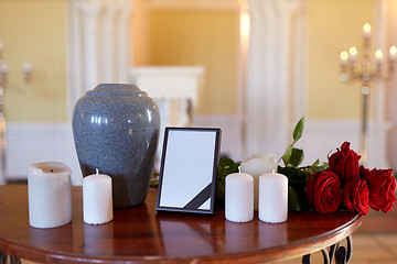 Image showing photo frame, cremation urn and candles in church